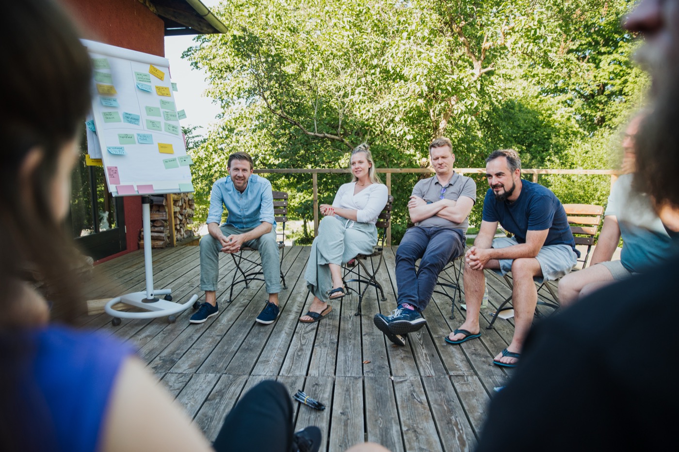 Teilnehmende des AI Retreat im Kreis auf der Terrasse